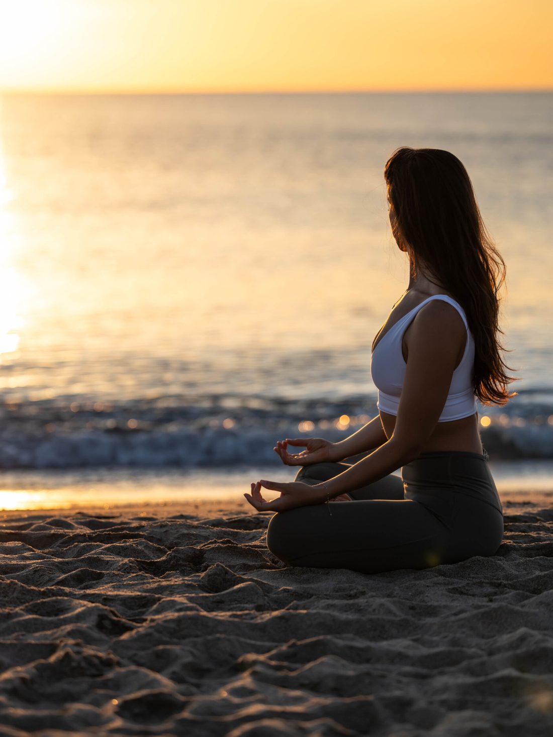 Méditation assise face à la mer au coucher du soleil