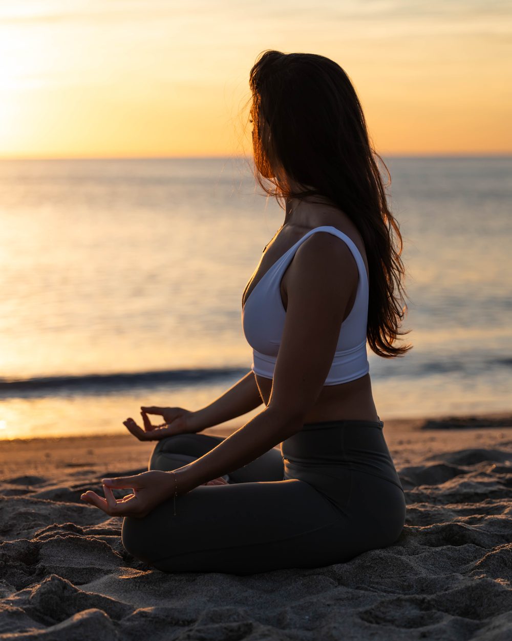 Daïna Rossignol en méditation sur la plage au coucher du soleil